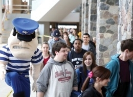 Louie the Laker and students check out the library